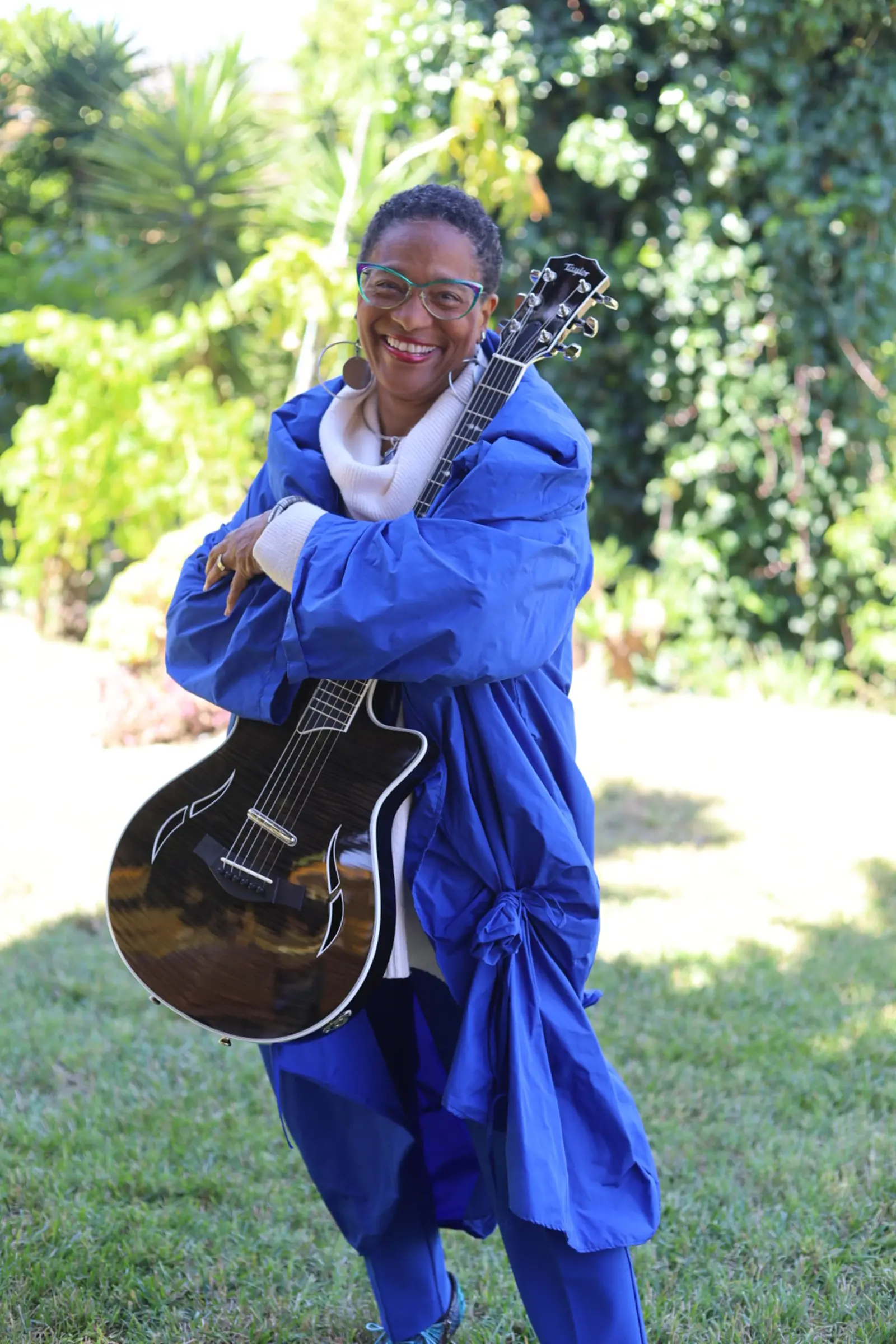 Sheree Brown with her Taylor guitar Heritage artist Sheree Brown holding her Taylor guitar in a garden